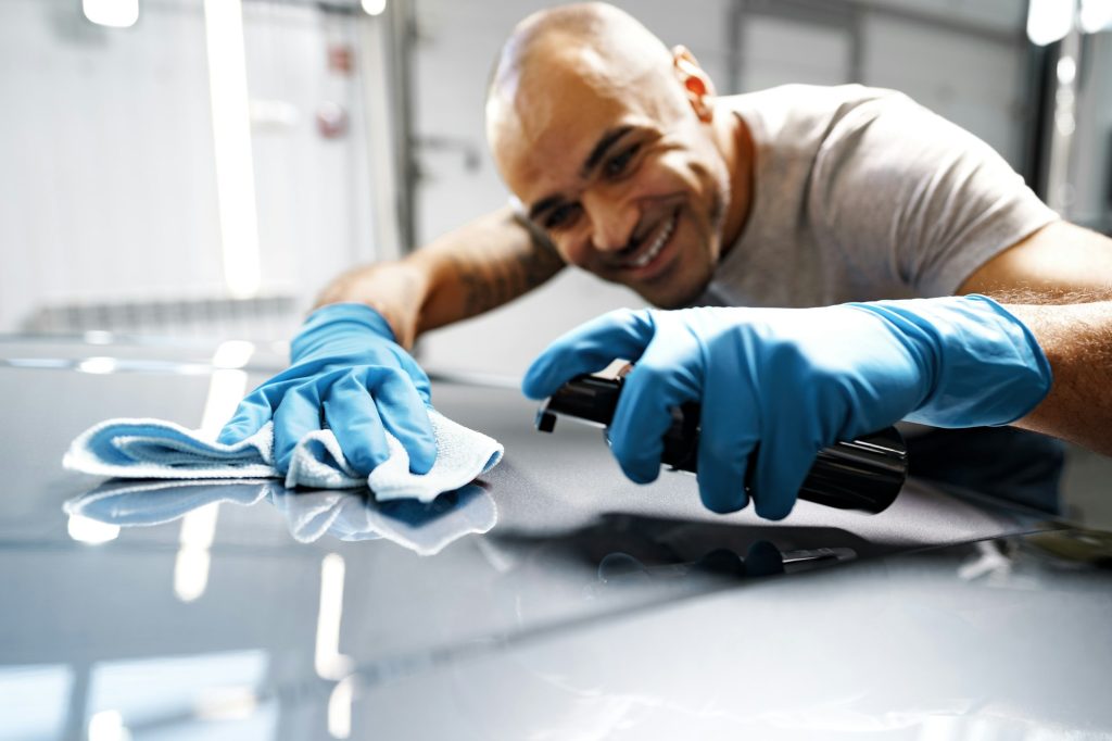 African American man car service worker applying nano coating on a car