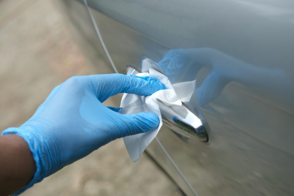 hand in spry bottle cleaning car door knob