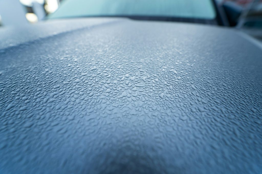 Raindrops on the hood of the car. Close-up